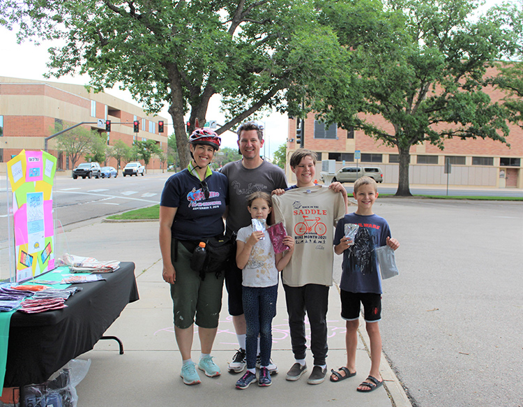 Family of cyclists stopped at a t-shirt station in downtown Greeley